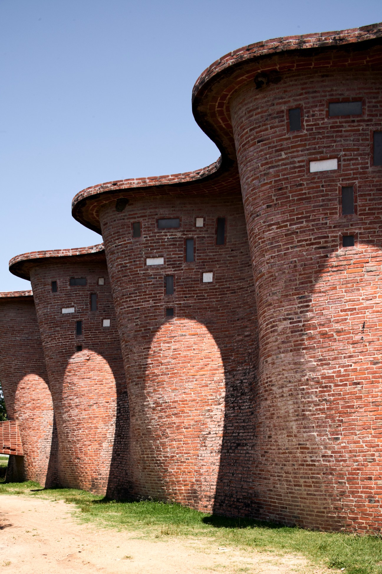 Curved red brick exterior wall of Cristo Obrero church showing flowing architectural lines