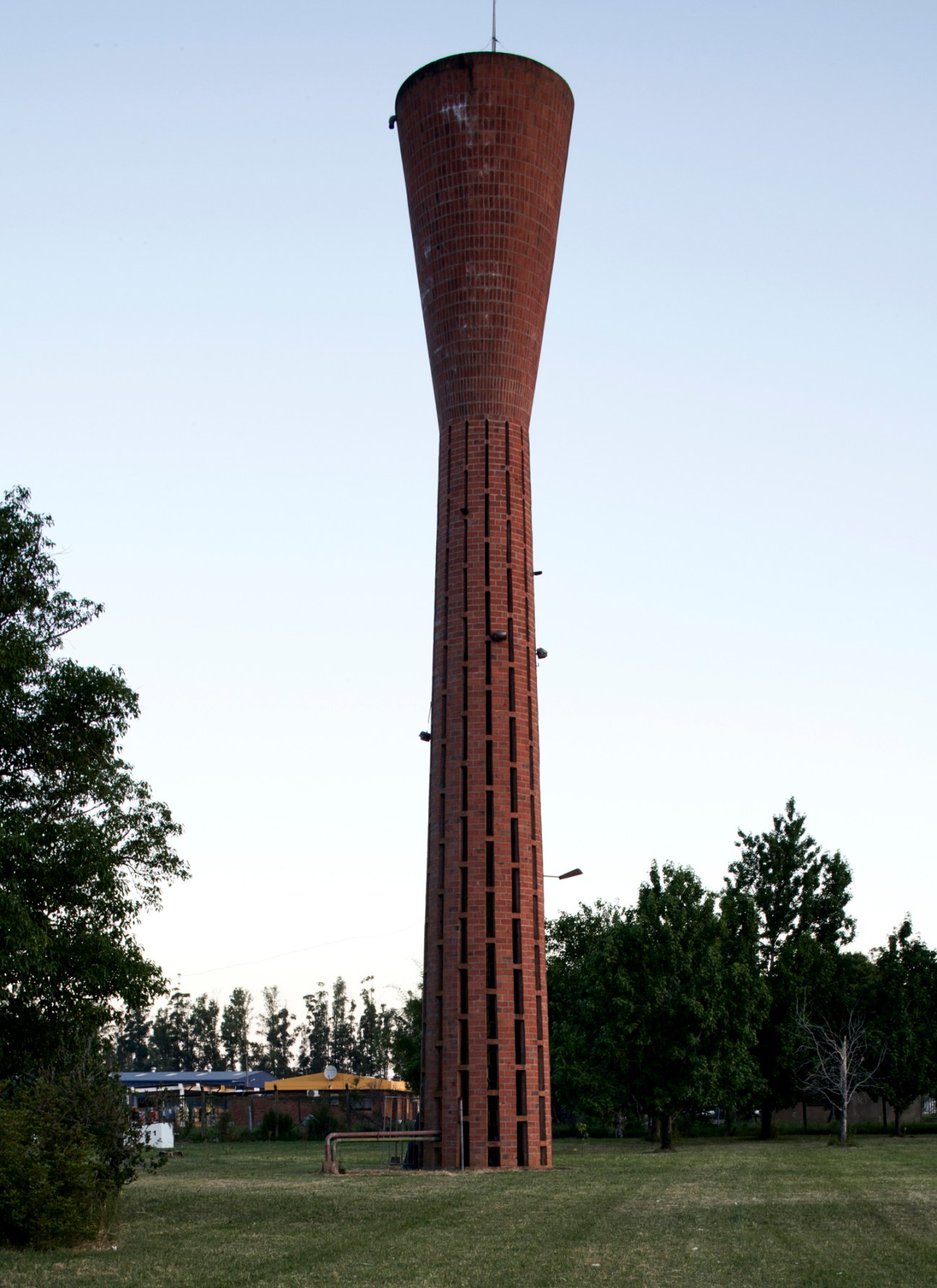 Tall cylindrical brick water tower with tapered design and industrial architecture