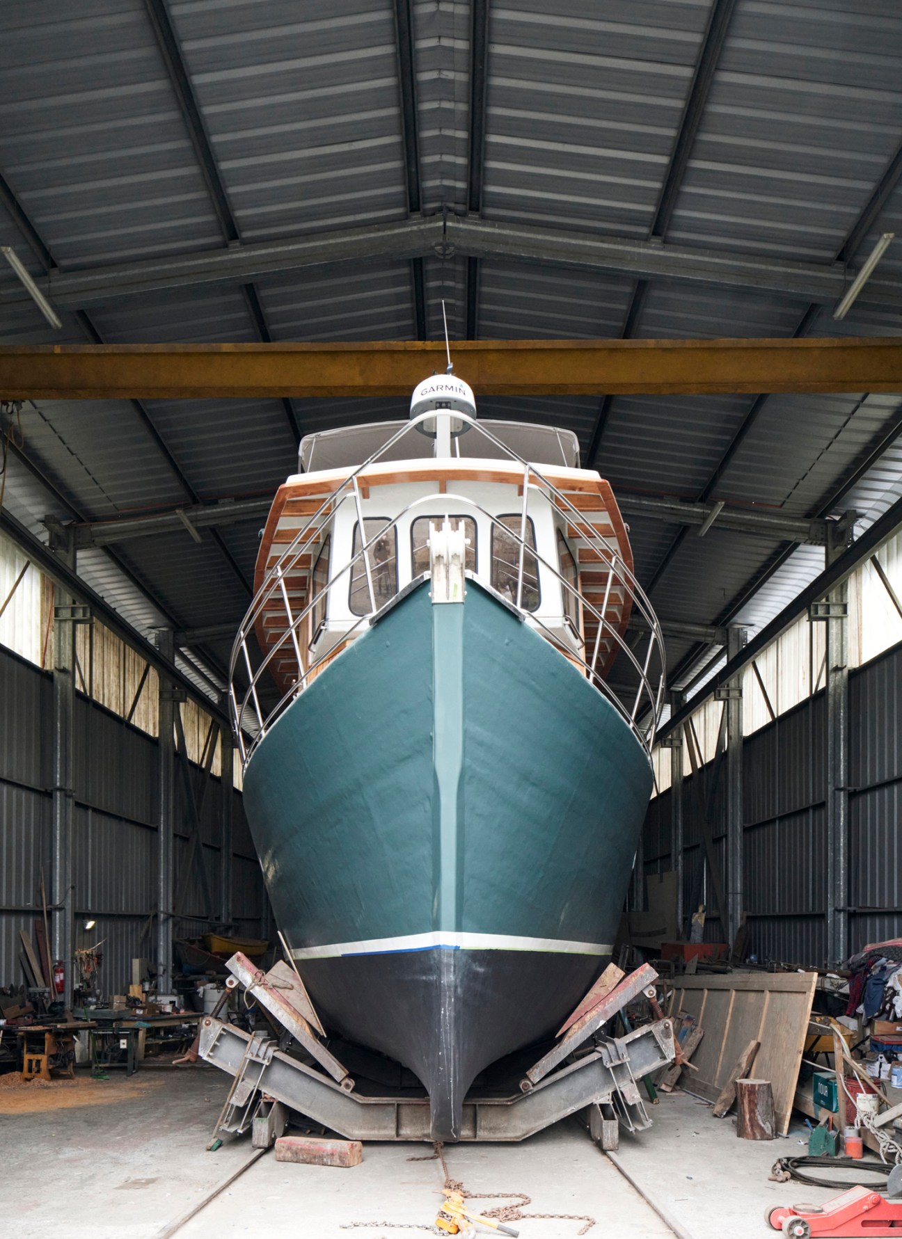 The fishing boat Kon Tiki at a shipyard during restoration work, painted in deep blue-green