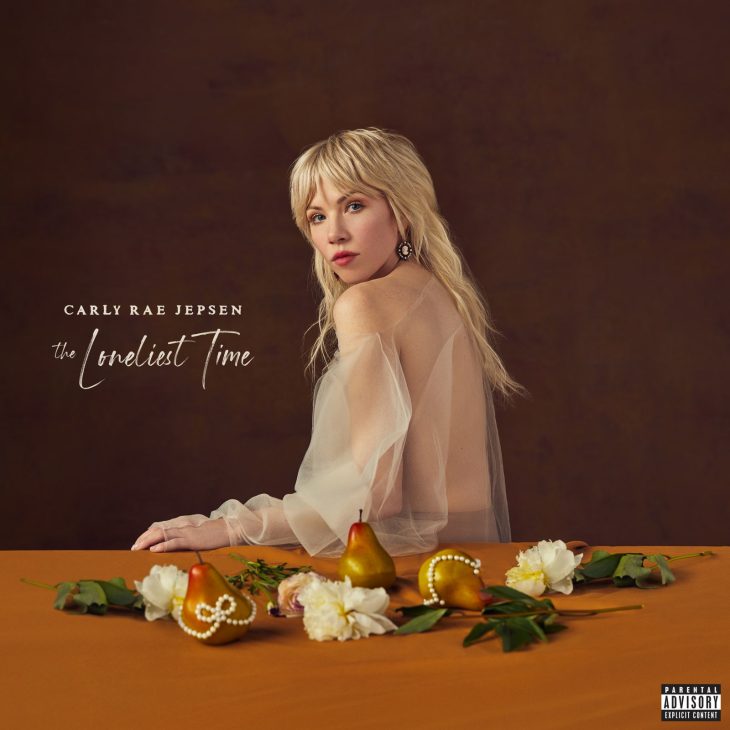 Album cover for The Loneliest Time by Carly Rae Jepsen showing blonde woman at table with fruit and flowers