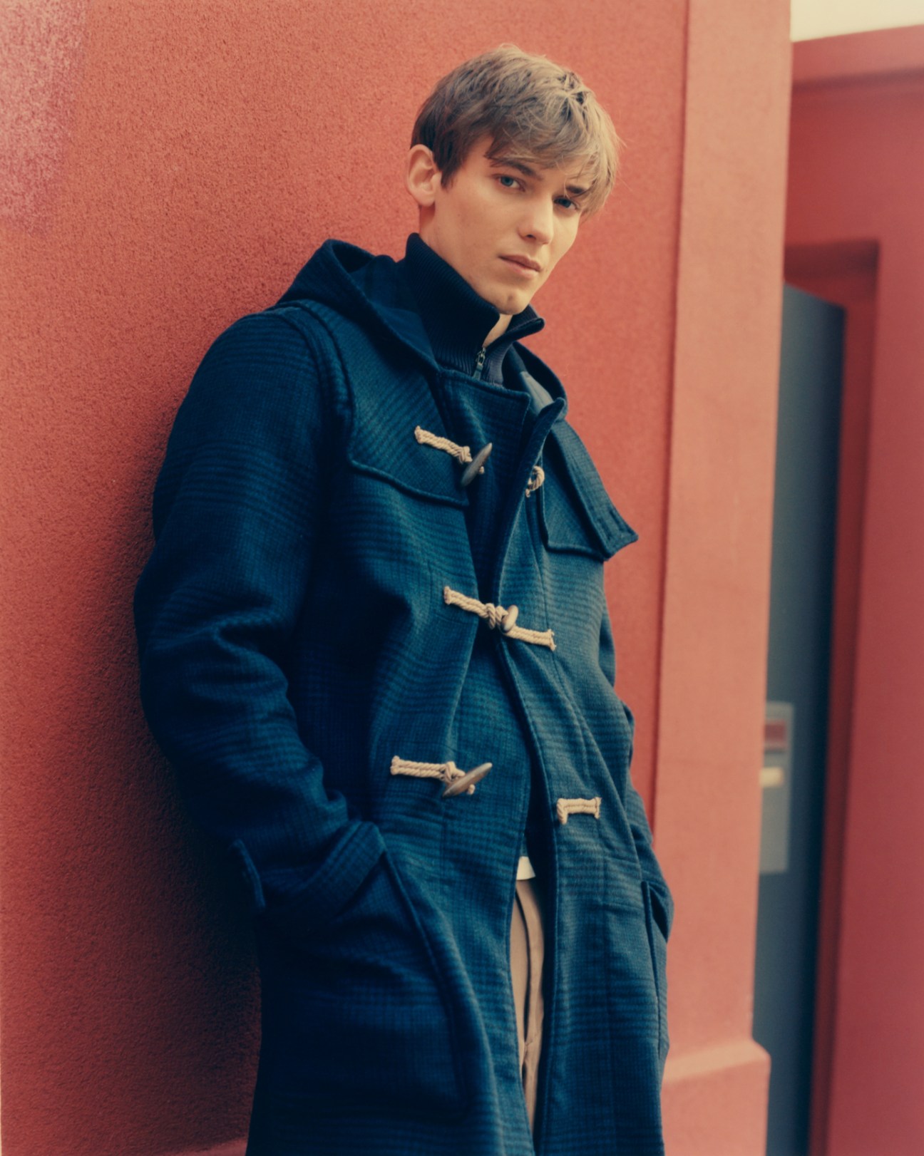 Model wearing coat by Handpicked, jumper by Herno, t-shirt by Uniqlo, and trousers by Margaret Howell