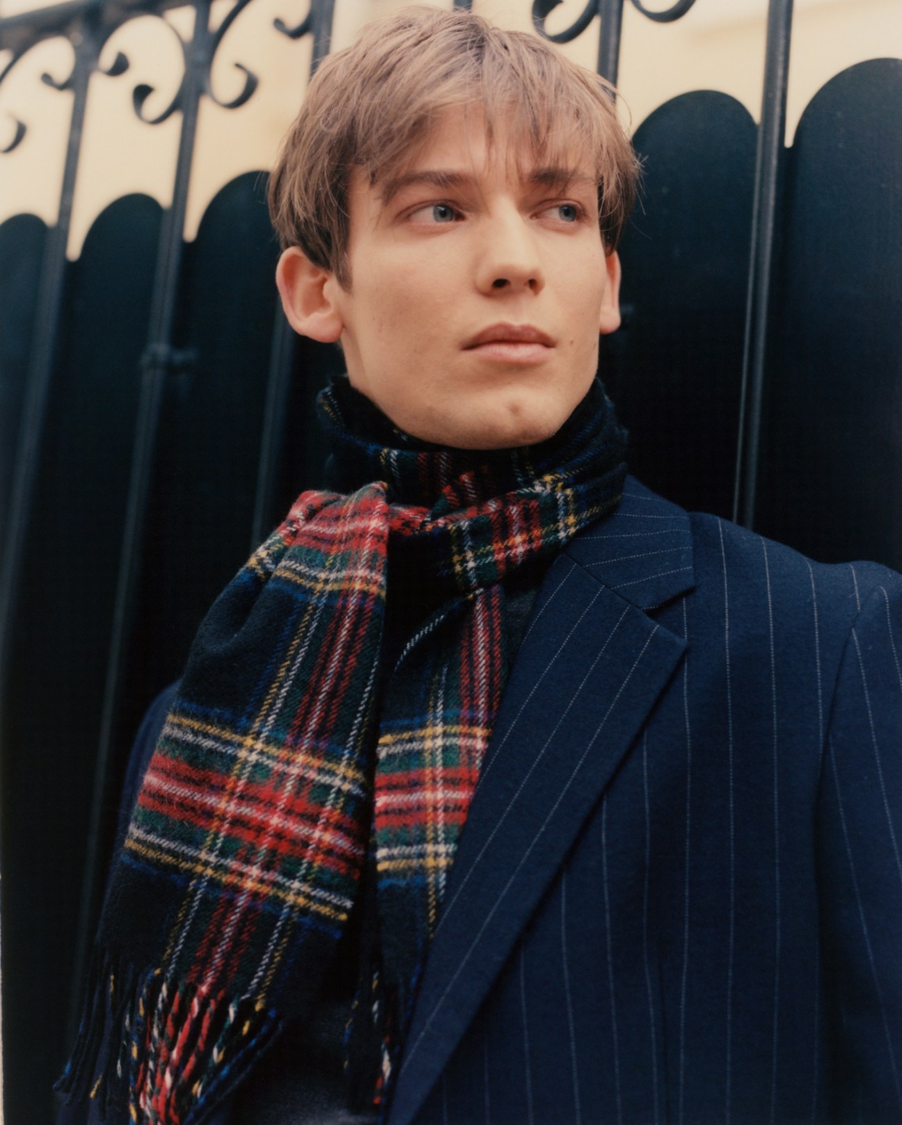 Model wearing jacket by Prada, jumper by Brioni, and scarf by Fred Perry
