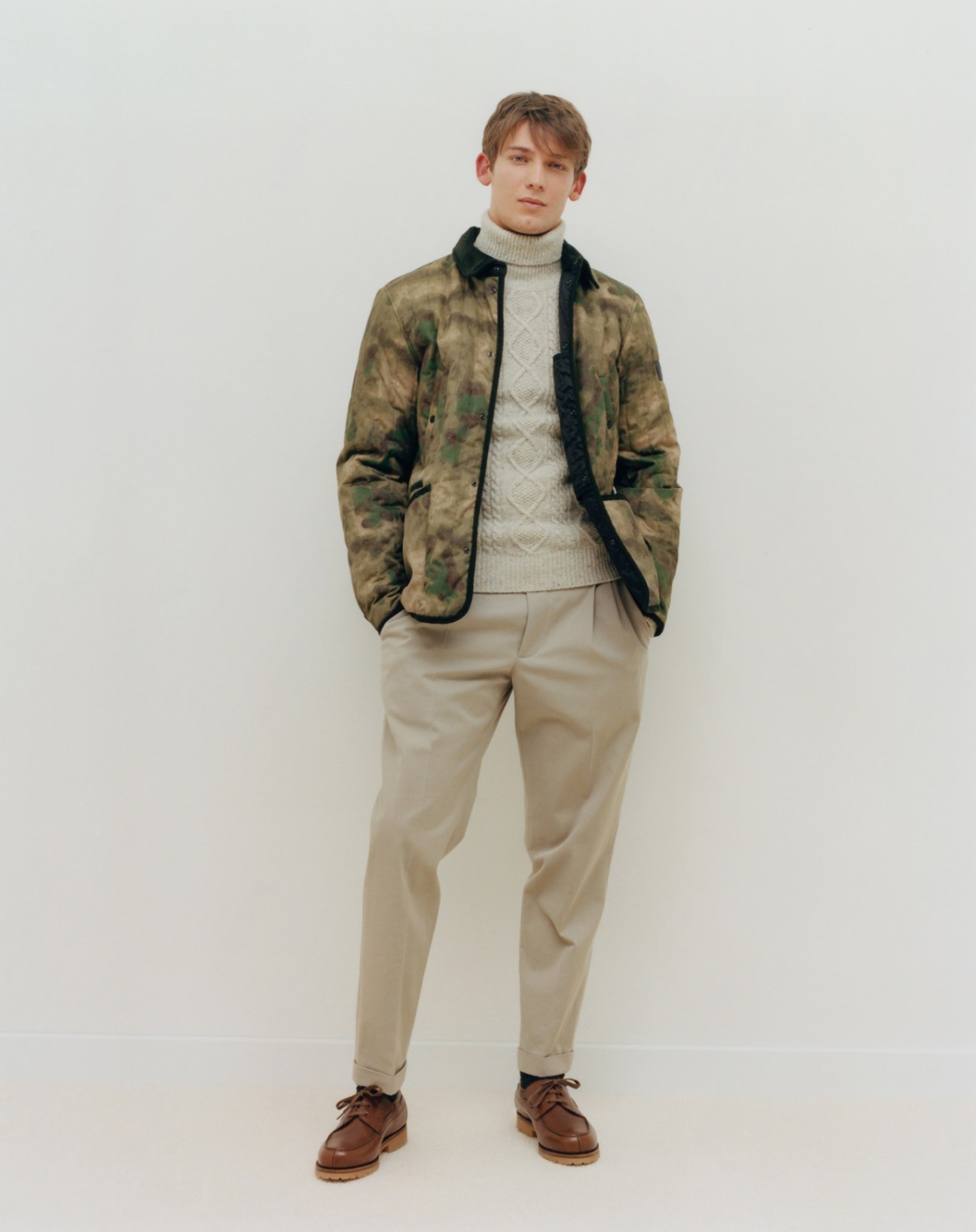 Model wearing jacket by Woolrich, jumper by Hartford, trousers by Brunello Cucinelli, socks by Falke, and shoes by JM Weston