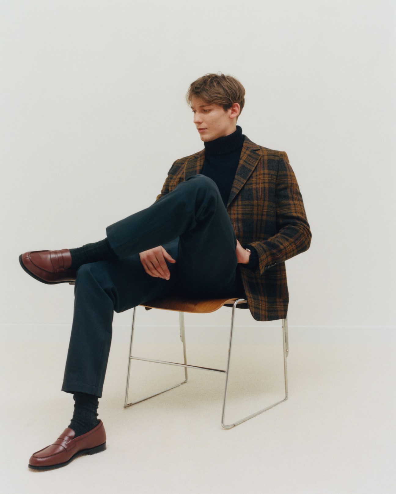 Model wearing jacket by A Kind of Guise, jumper by Anderson & Sheppard, trousers by Kidur, socks by Falke, shoes by JM Weston, and watch by Tag Heuer