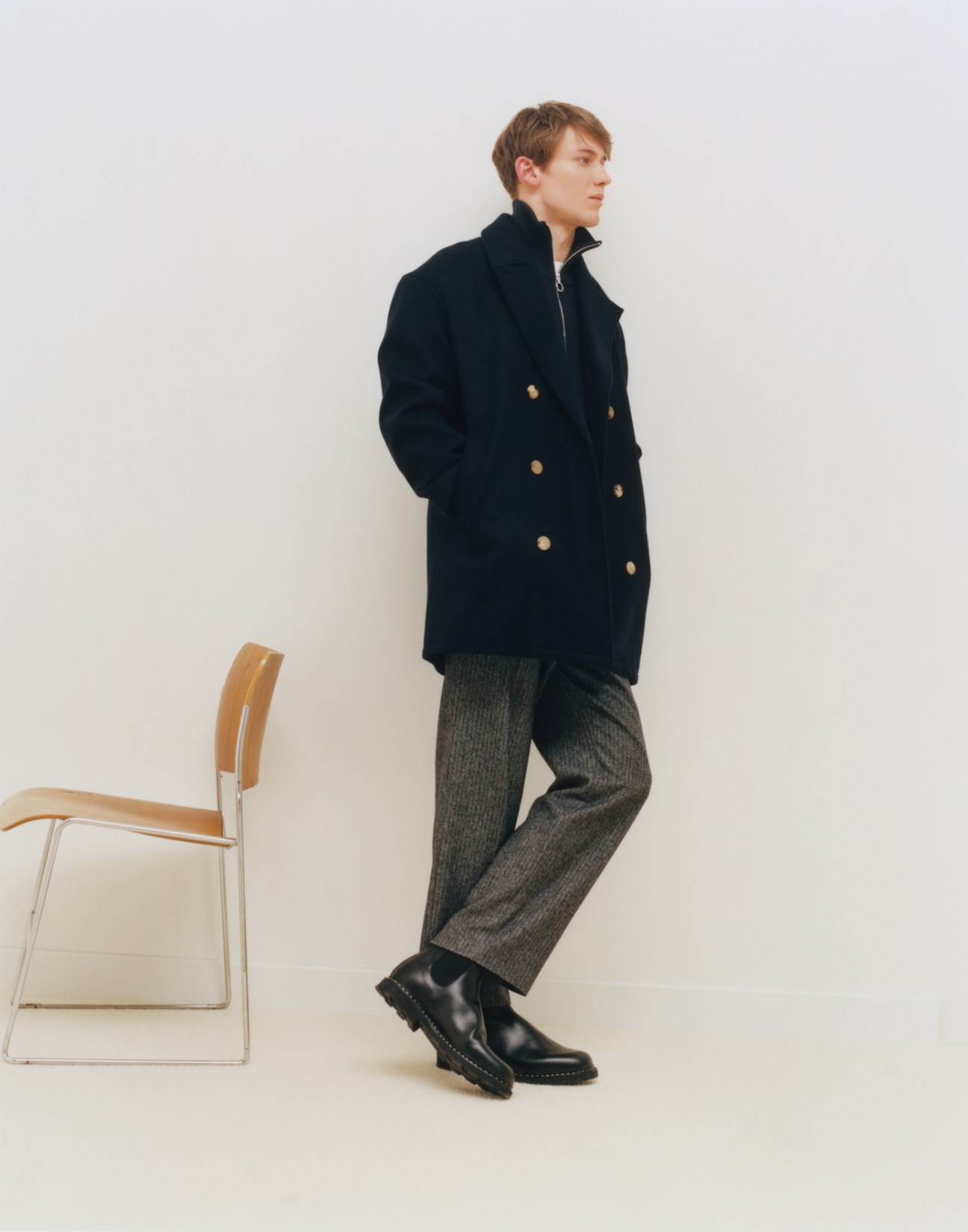 Model wearing coat by De Bonne Facture, jumper by Armani Exchange, t-shirt by Uniqlo, trousers by Agnès B, and boots by Paraboot