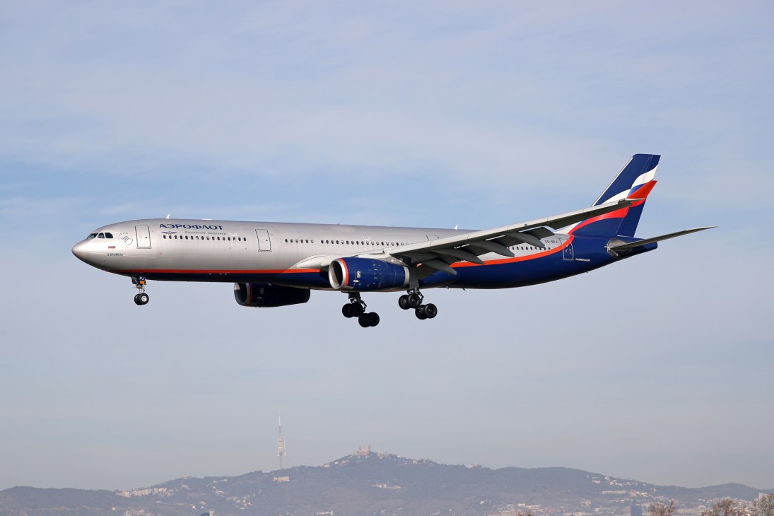 Aeroflot aircraft in flight against cloudy sky with mountains visible below