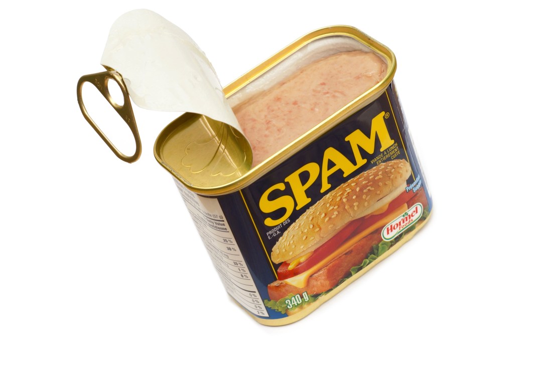 Open can of Spam showing pink processed meat inside with distinctive blue and yellow packaging