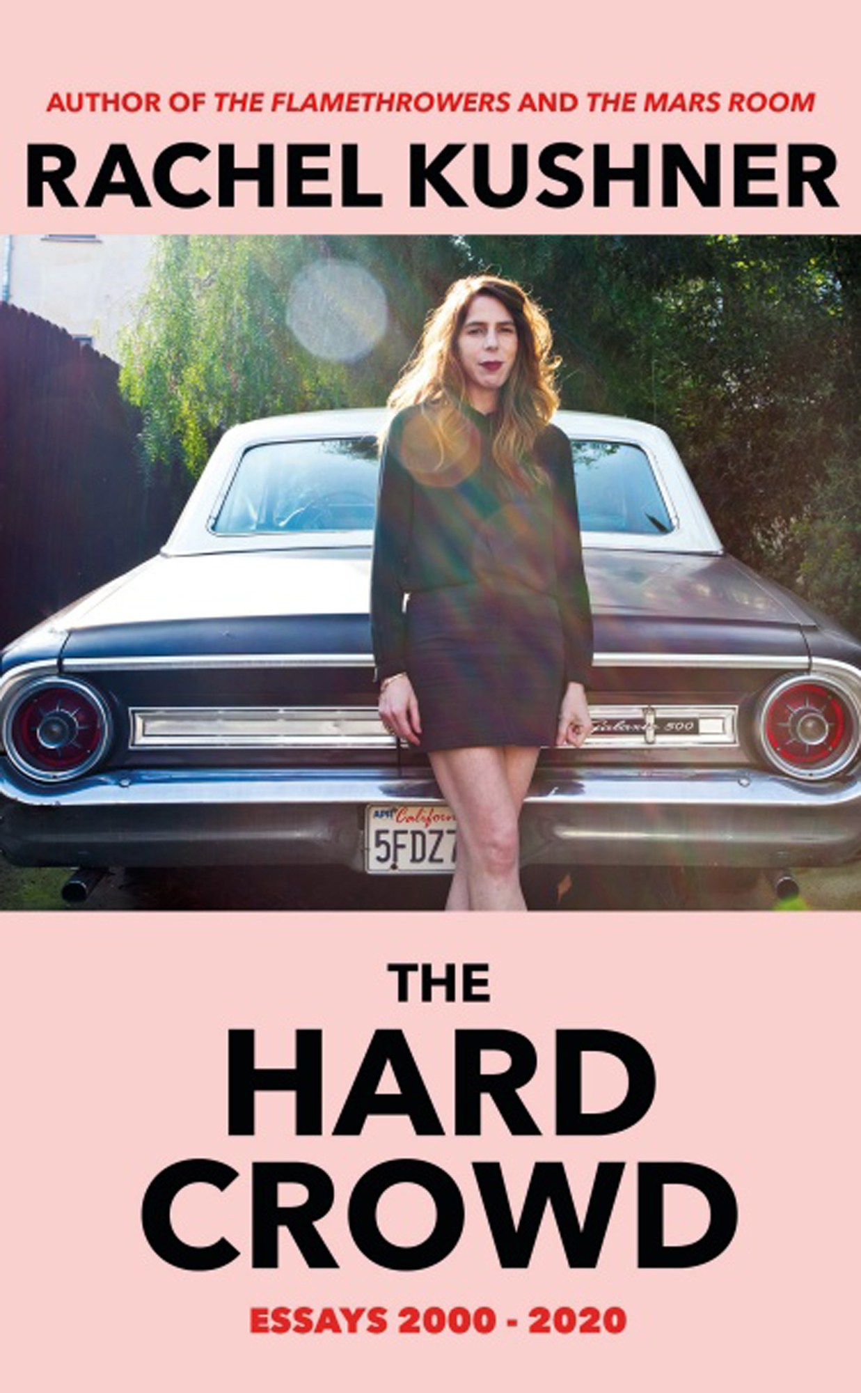 Book cover of The Hard Crowd by Rachel Kushner showing a woman standing in front of a vintage car