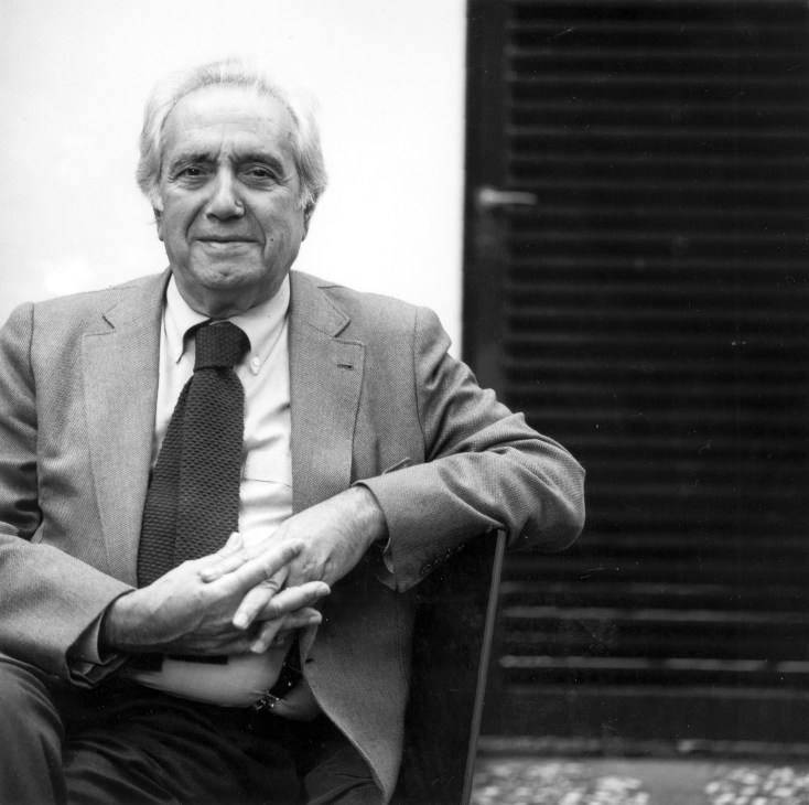 Black and white portrait of an elderly man in a suit and tie sitting in a chair