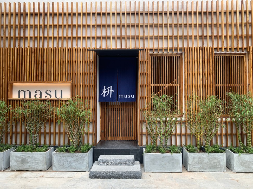 Masu restaurant exterior facade with geometric wooden lattice pattern in Hanoi, Vietnam.