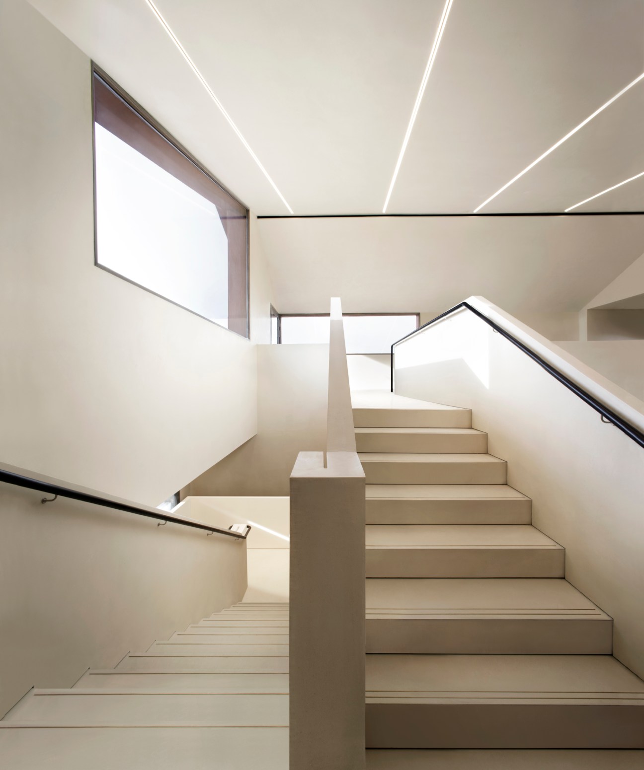 Modern staircase with white steps and handrails in renovated Procuratie Vecchie building by David Chipperfield Architects