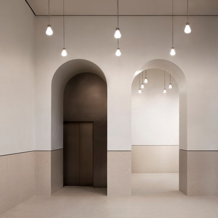 Modern minimalist interior with arched doorways, pendant lighting, and neutral tones