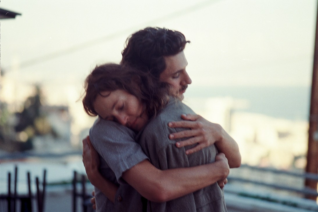 Two people embracing in an intimate hug outdoors in soft lighting