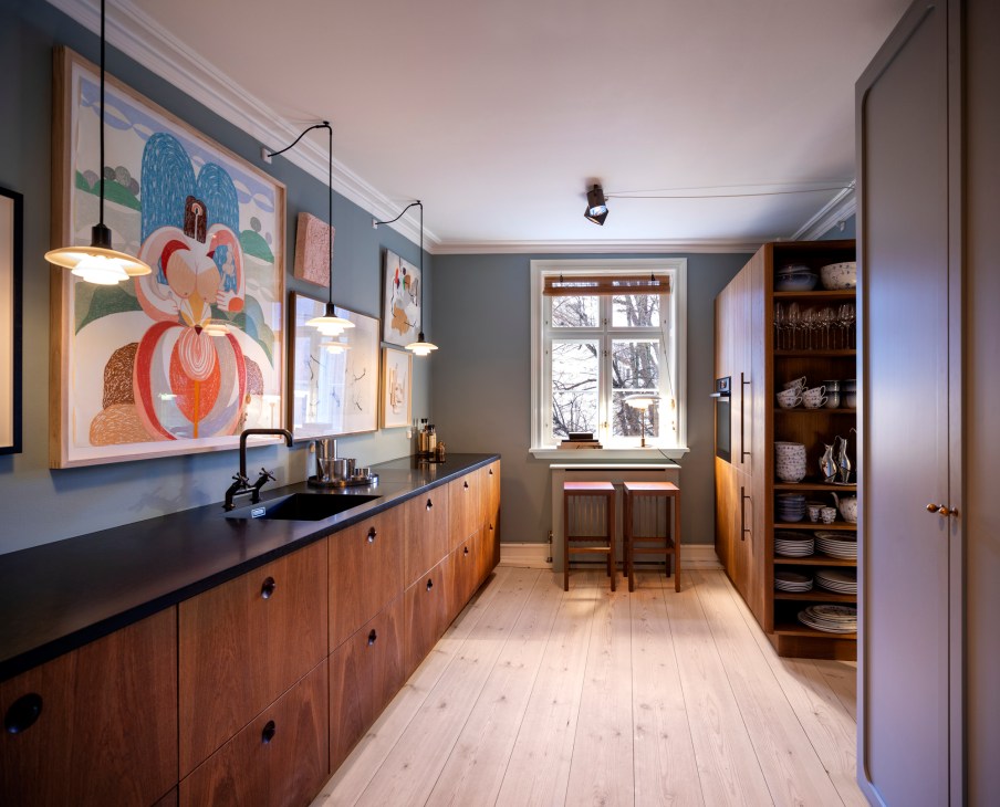 The Darling hotel kitchen with smoked oak cabinetry, contemporary art, and pendant lighting.