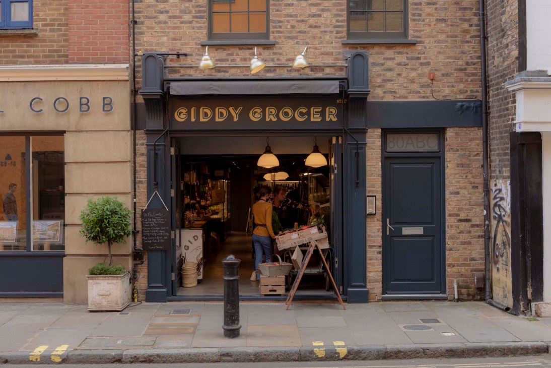 Christine Hall, owner of Giddy Grocer, standing in her shop surrounded by carefully curated products