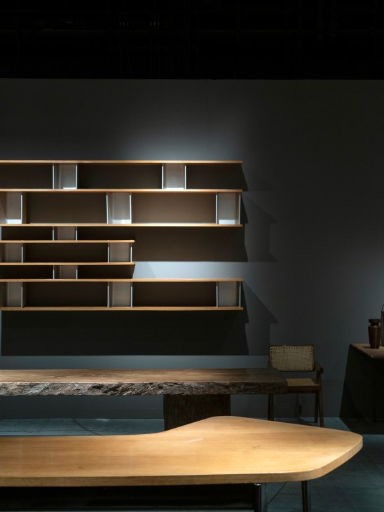 Modern shelving unit with wood and metal frame displayed alongside rustic wooden table