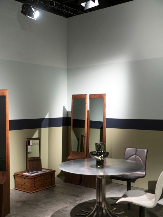 Maria Bruun furniture display featuring round table with chairs and mirrors in exhibition booth