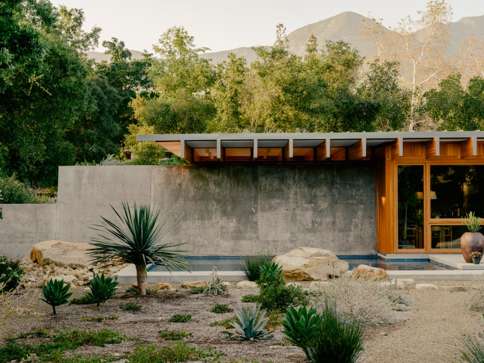 Large natural boulders arranged in landscaped backyard garden area with desert plants and gravel ground cover