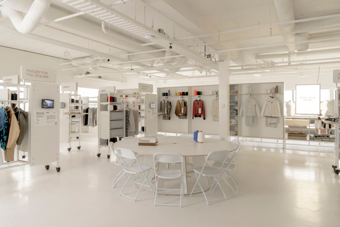 Modern meeting area with white tables and chairs in the Woto textile innovation showroom