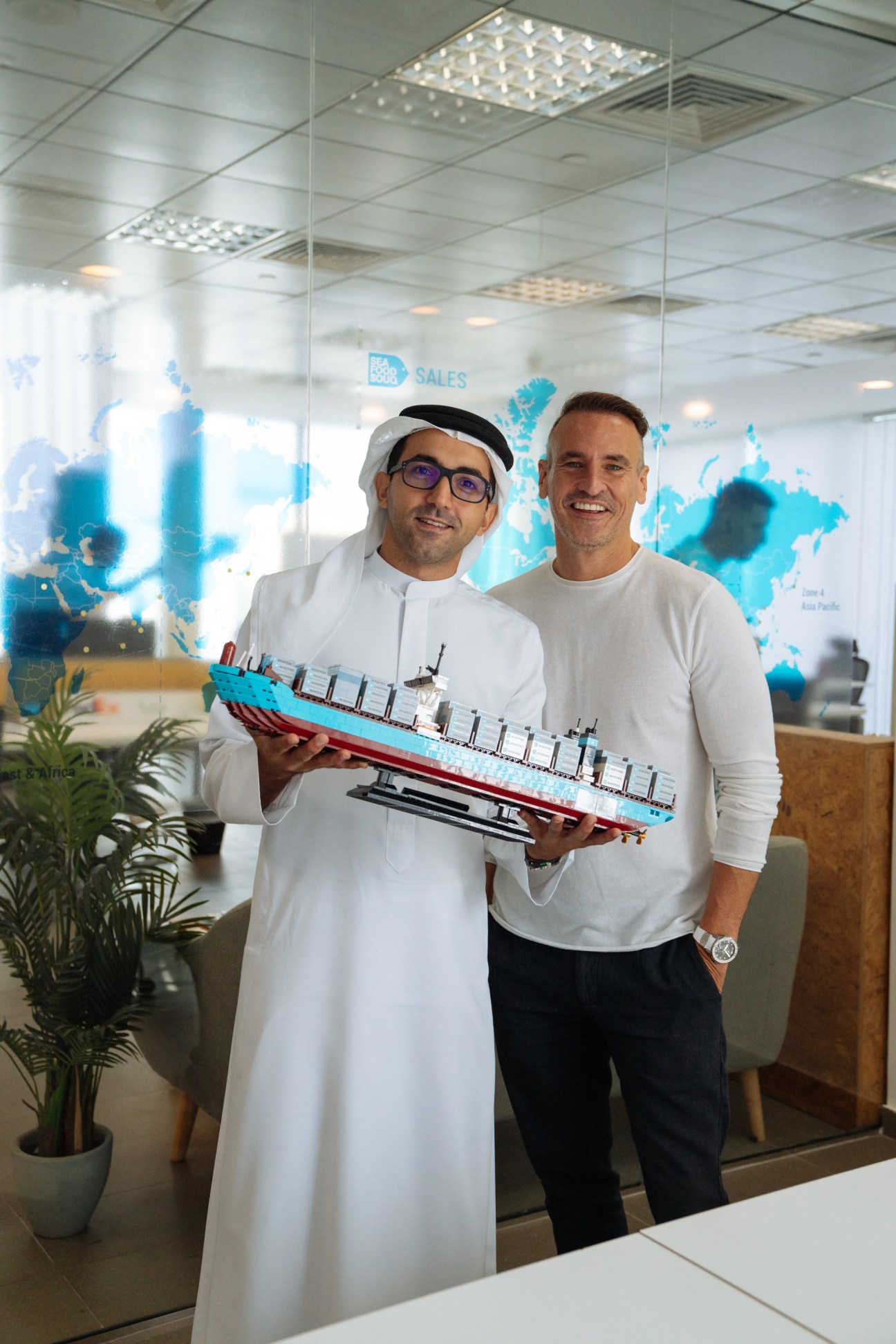 Fahim Al Qasimi and Sean Dennis of Seafood Souq holding a model ship in their office