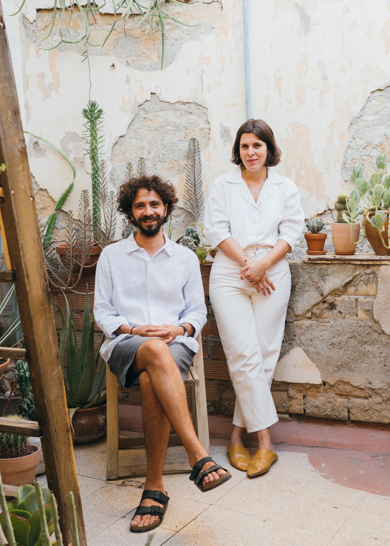 Architect Michalis Anastasiou and partner Alex Petsetakis standing together in their neoclassical building courtyard