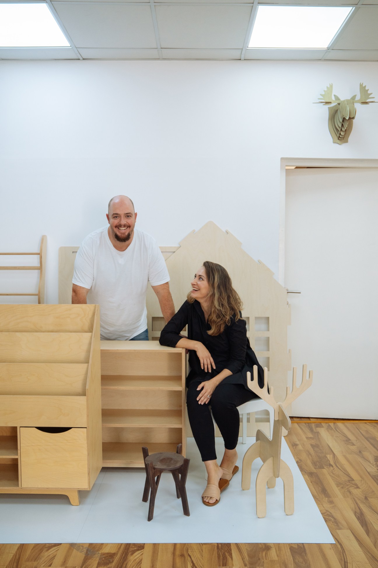 Adam and Viara Nicholson, co-founders of Plyconcept, pose with handmade Baltic birch furniture in their Dubai studio.