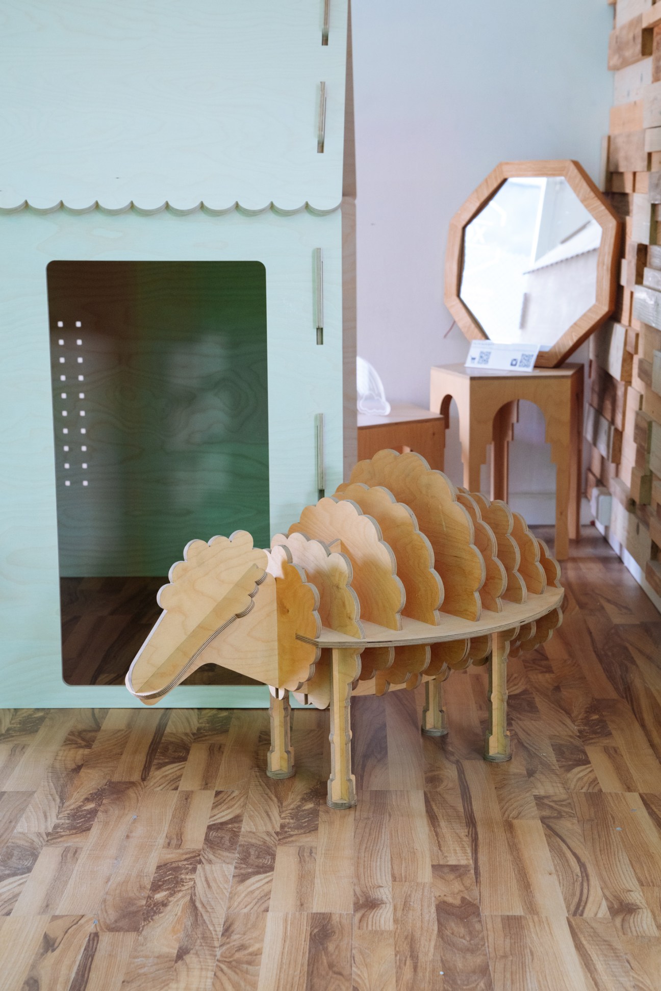 Wooden furniture piece with scalloped design by Plyconcept displayed in studio setting with mirror.