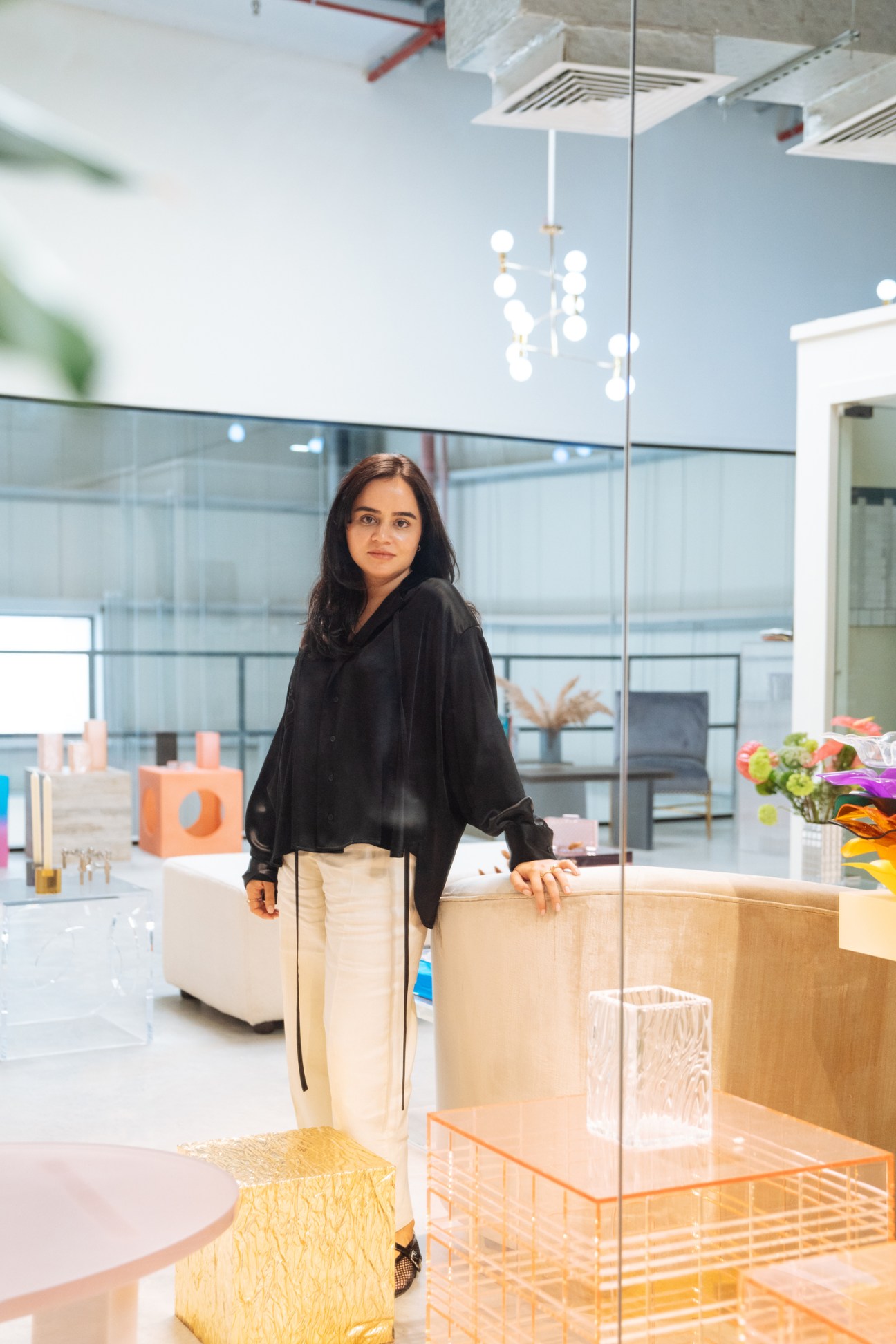 Lilian Afshar stands in her modern Dubai studio workshop, surrounded by acrylic handbags and accessories