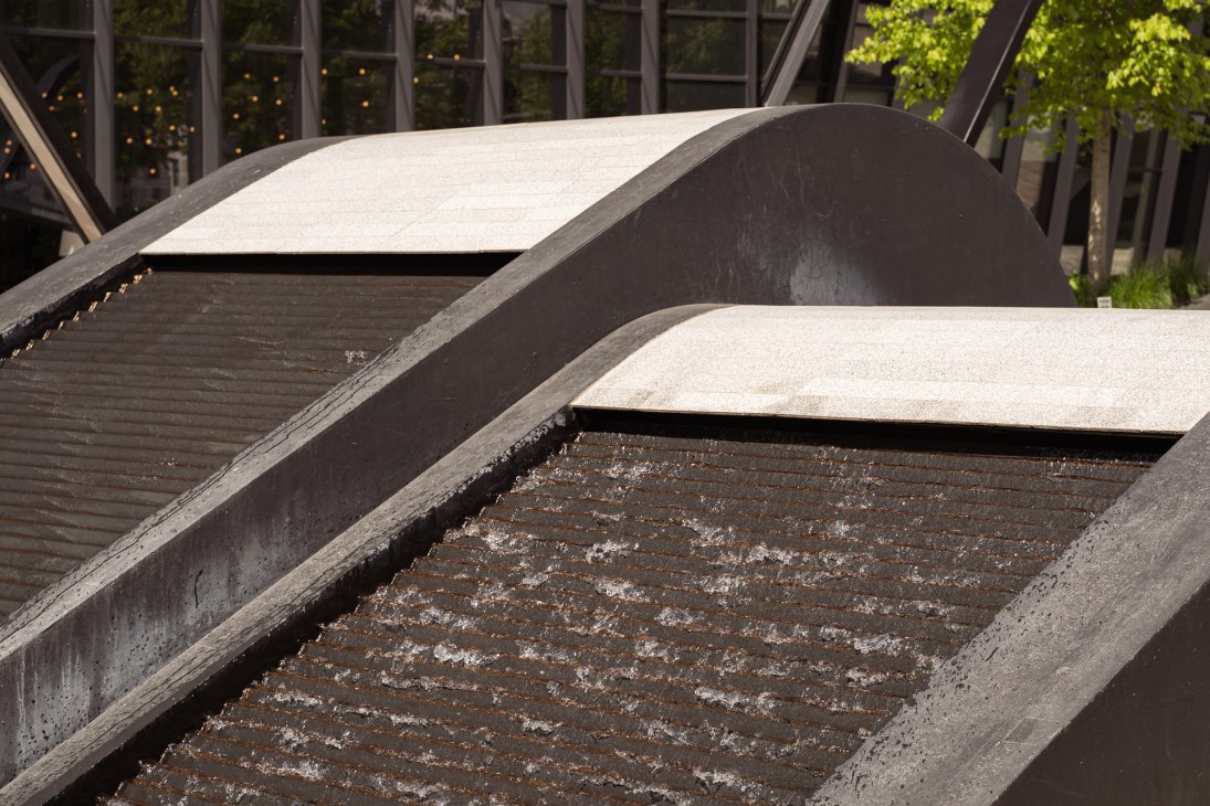 Curved concrete water features with flowing water in Vilnius Plaza