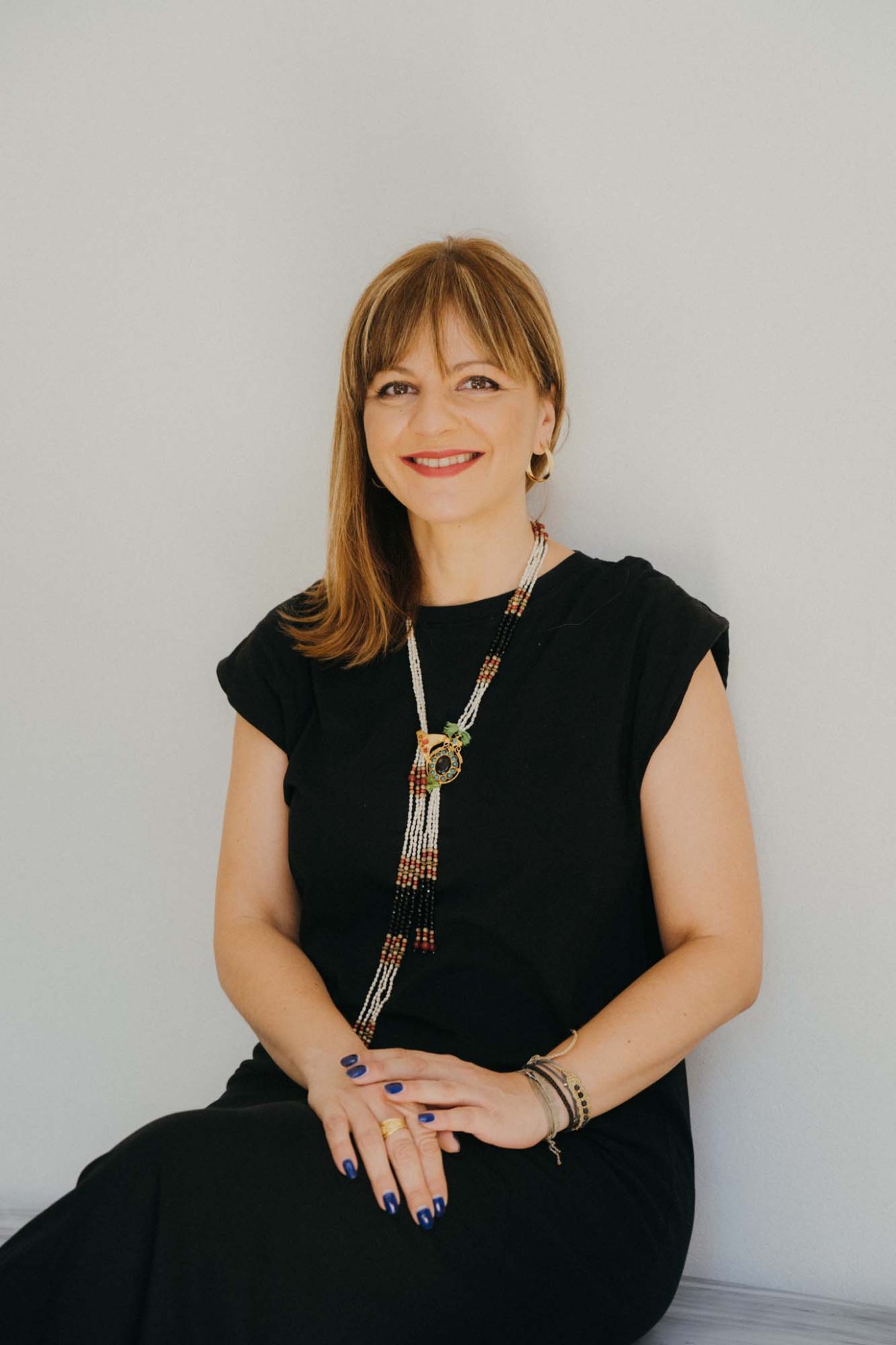Portrait of Sophia Sapouna, Molonglo's Athens operations manager, wearing black sleeveless top and beaded necklace