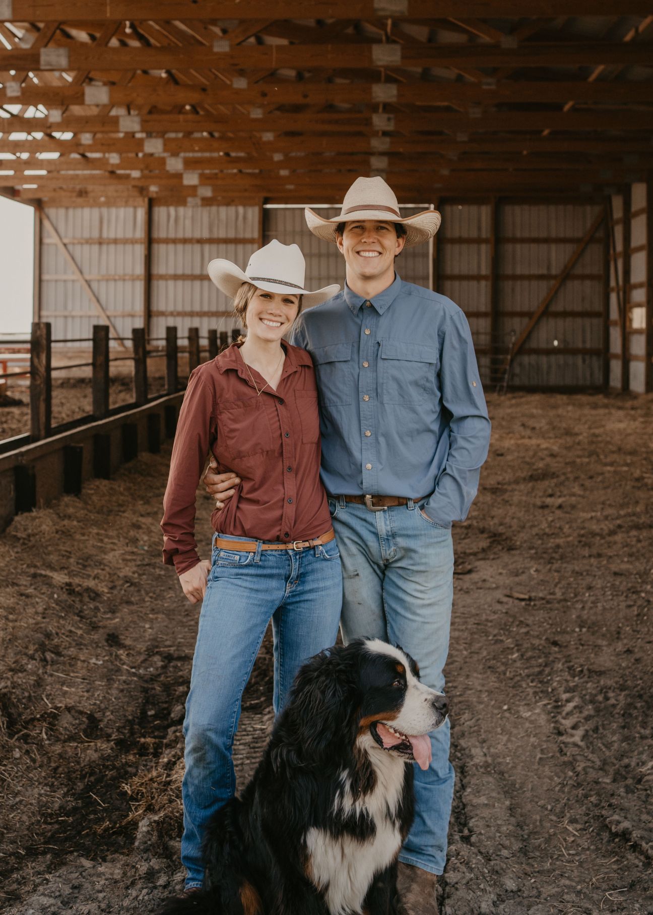 Amanda and Knute Severson, owners of Grand View Beef, stand with their dog in a barn at their Iowa ranch.
