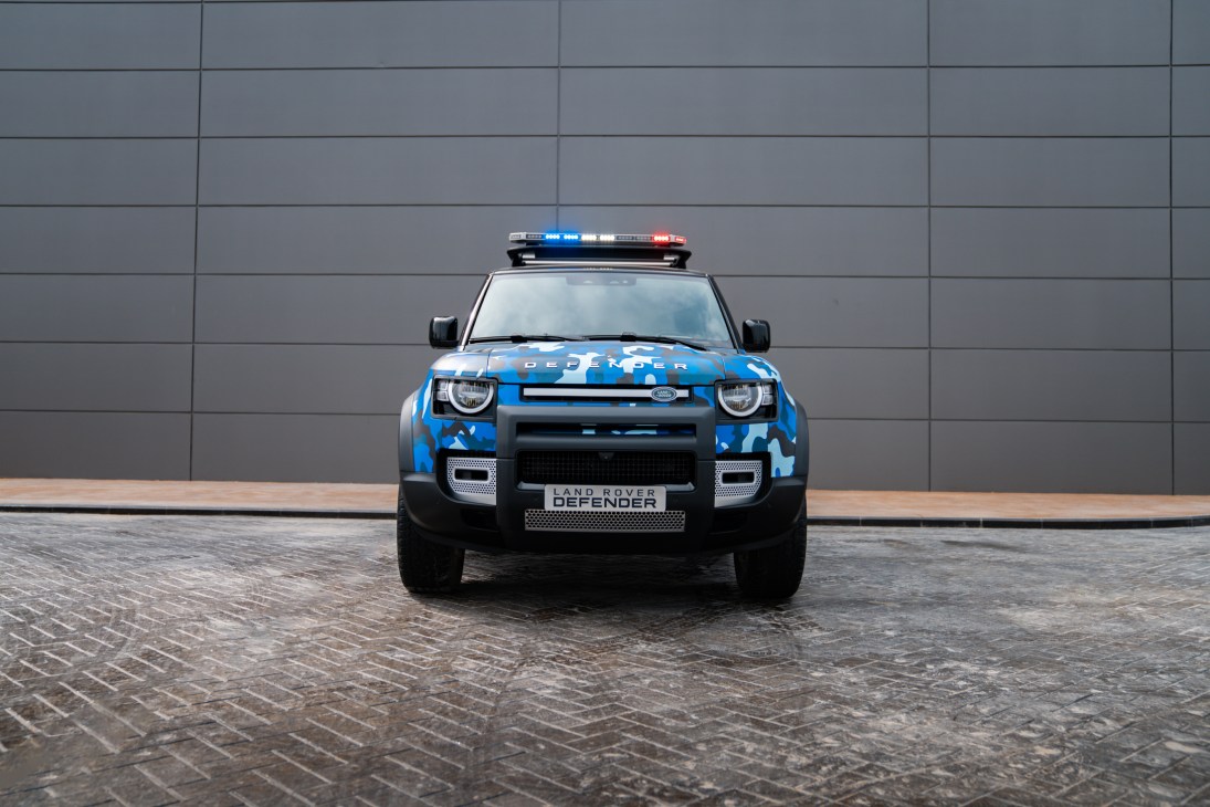 Land Rover Defender police vehicle with blue camouflage livery and emergency light bar