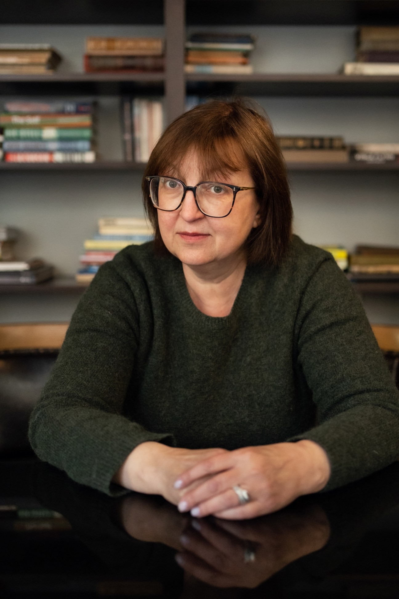 Galina Timchenko, CEO of independent Russian news outlet Meduza, sitting at desk with bookshelves behind her