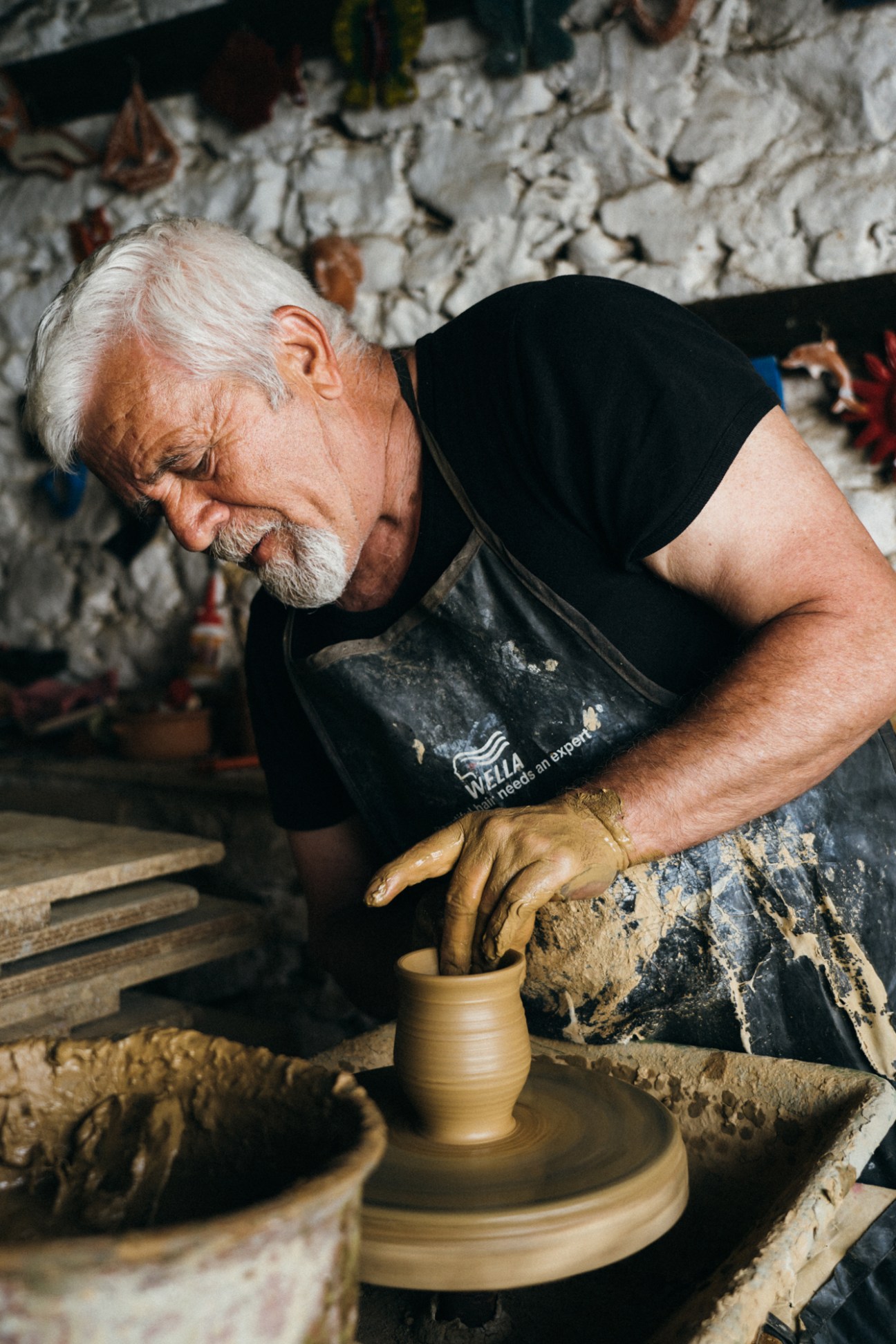 Costis Chrysogelos shapes clay on a pottery wheel at his family ceramic studio on Thassos.