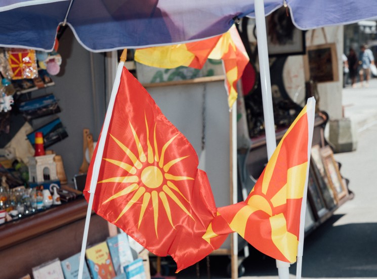 Macedonian flags and postcards displayed at a souvenir stand in North Macedonia