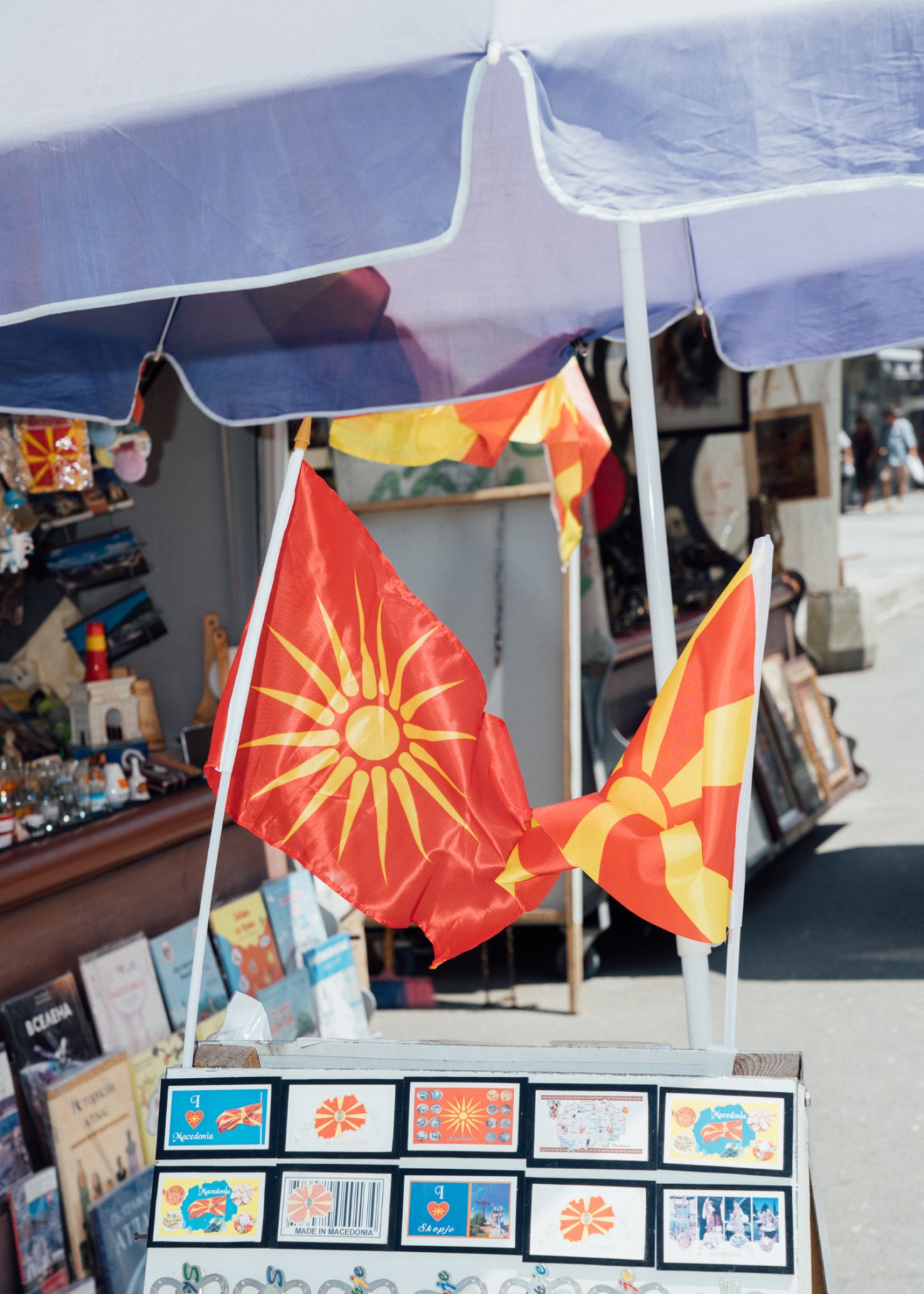 Macedonian flags and postcards displayed at a souvenir stand in North Macedonia
