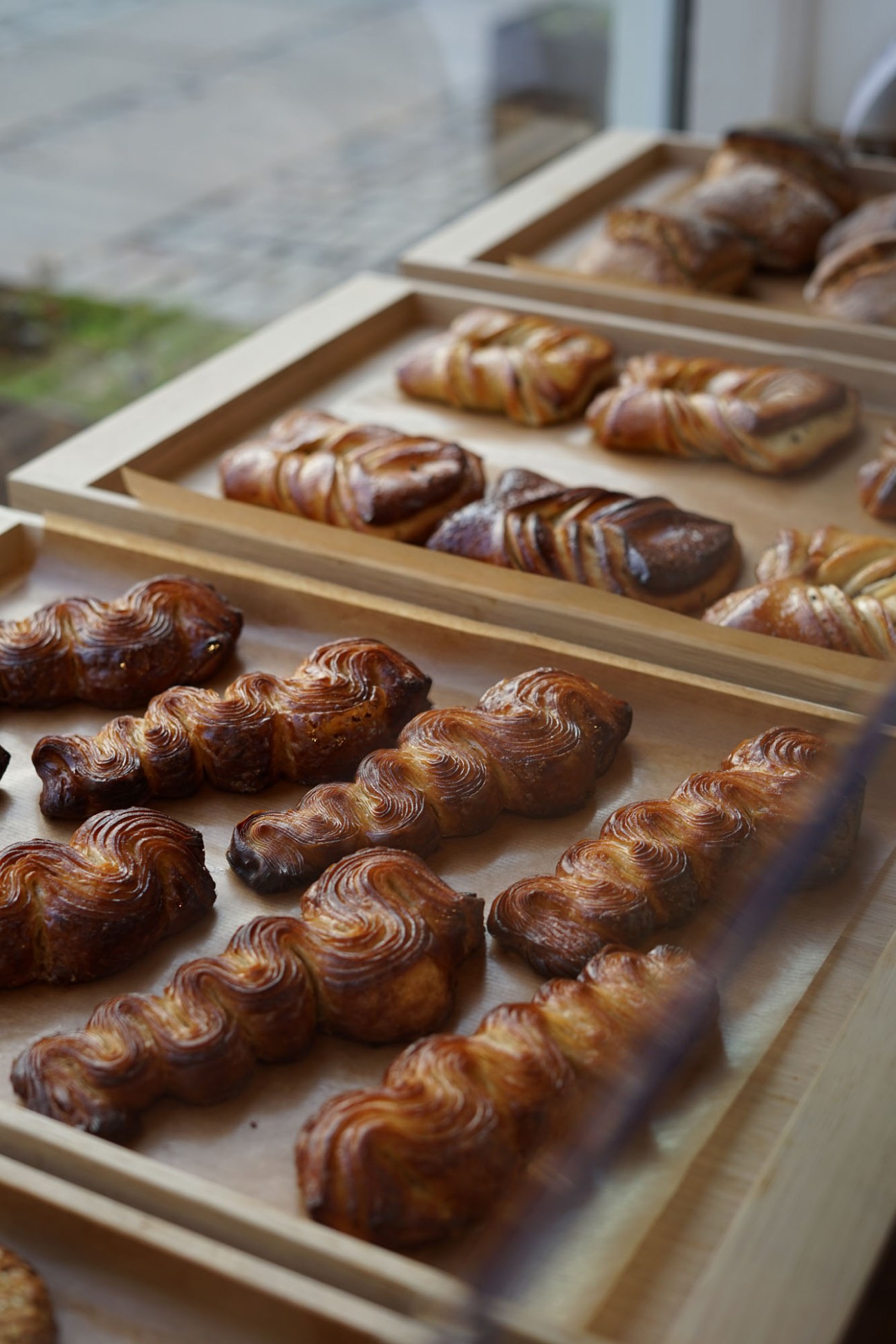 Golden-brown twisted pastries arranged on wooden display trays at Copenhagen bakery