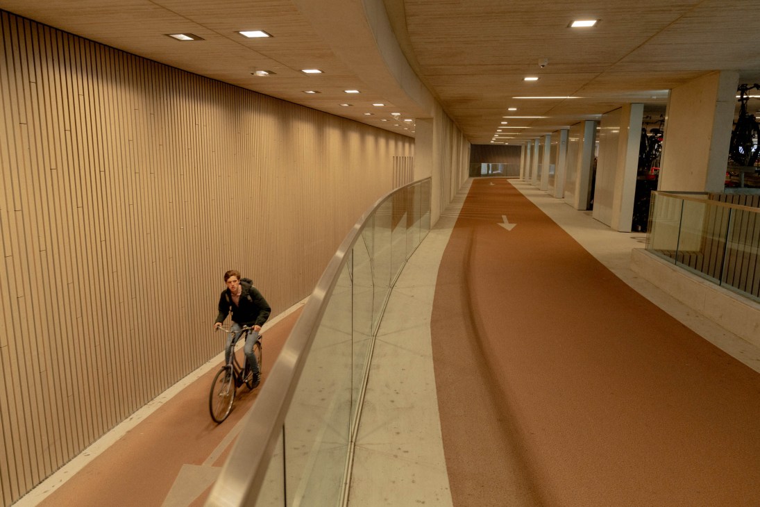 Modern covered walkway with cycling path and pedestrian areas featuring wood paneling and recessed lighting