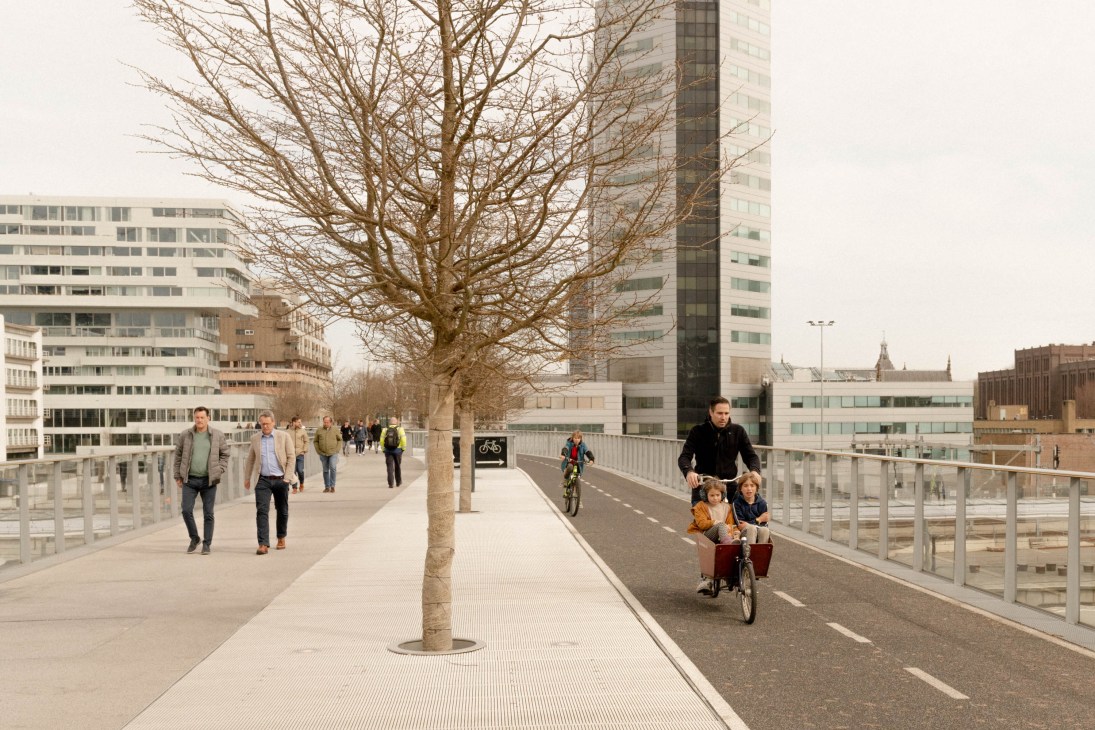 Modern bridge with pedestrian walkway and dedicated bicycle lane separated by railings in Dutch urban setting