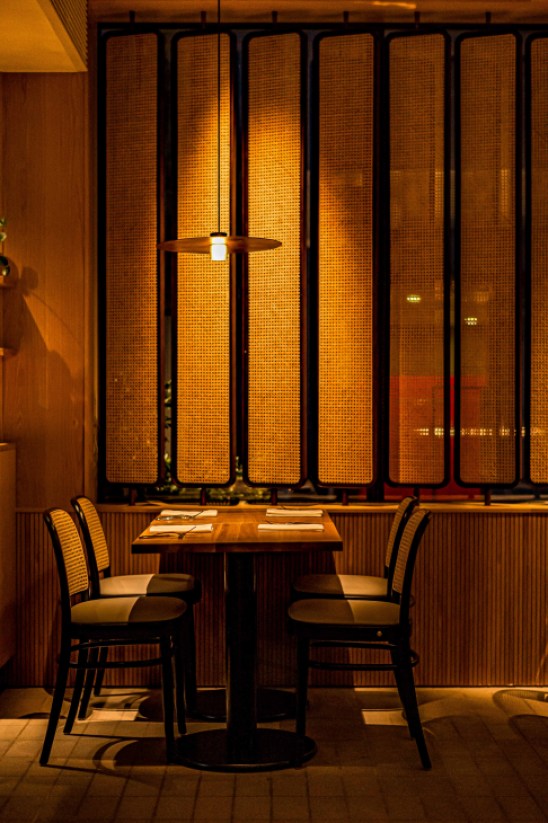 Interior view of the restaurant dining room in the evening with warm lighting and diners