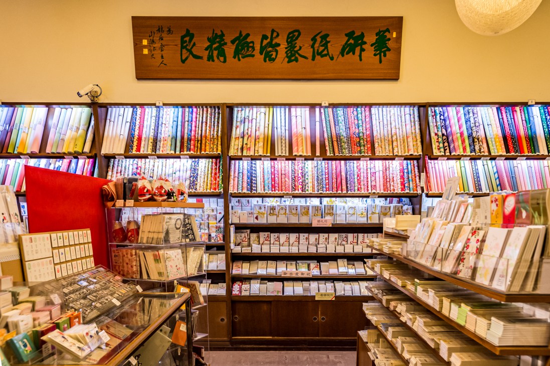 Interior of Kyukyodo stationery shop with wooden shelves displaying colorful paper products and books