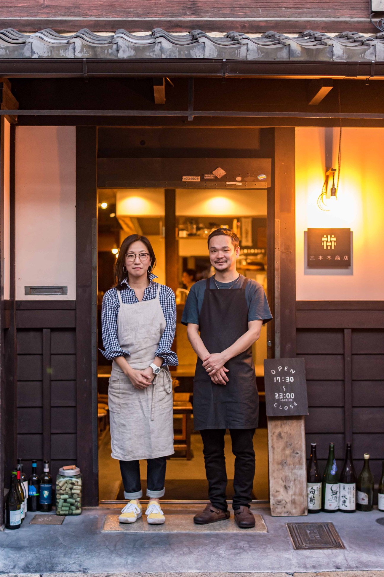 Chef Fumihiko Kono and his wife Yuki standing in the doorway of their restaurant Sanbongi Shoten in Kyoto