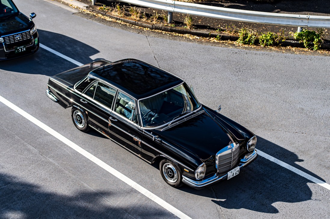 Side view of vintage Mercedes-Benz W108 parked on street showing elegant profile with some visible rust patina