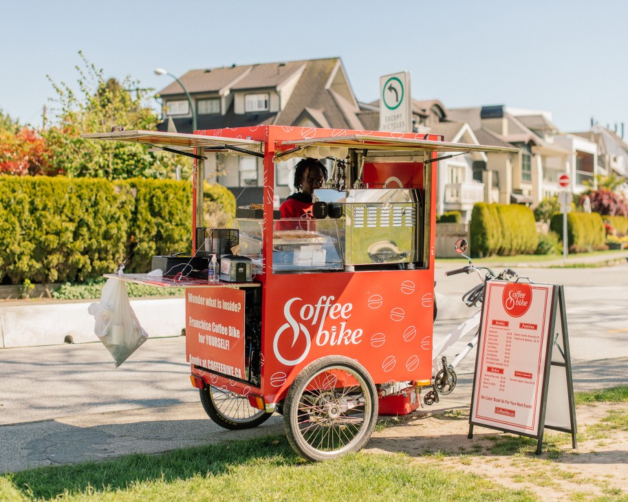 Coffee Spike mobile bicycle cart vendor serving customers on residential street