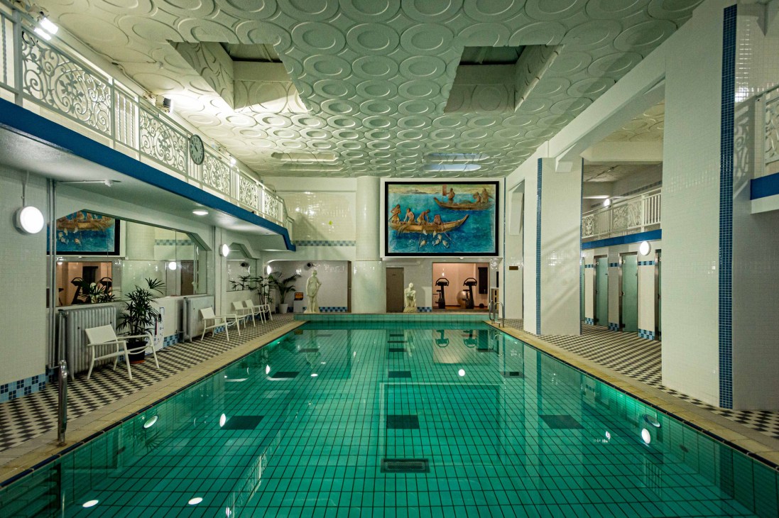 Indoor swimming pool at Fujiya Hotel with art deco ceiling design, turquoise water, and classical architectural details