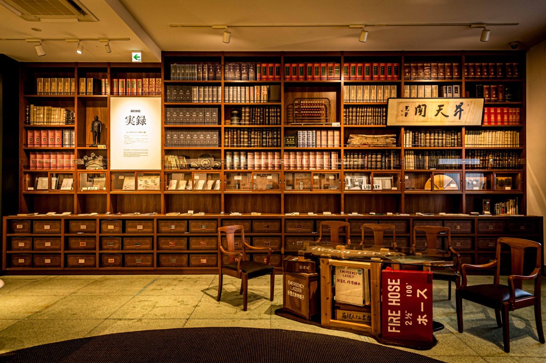 Traditional library room with floor-to-ceiling wooden bookshelves, drawers, and vintage furniture at Fujiya Hotel museum