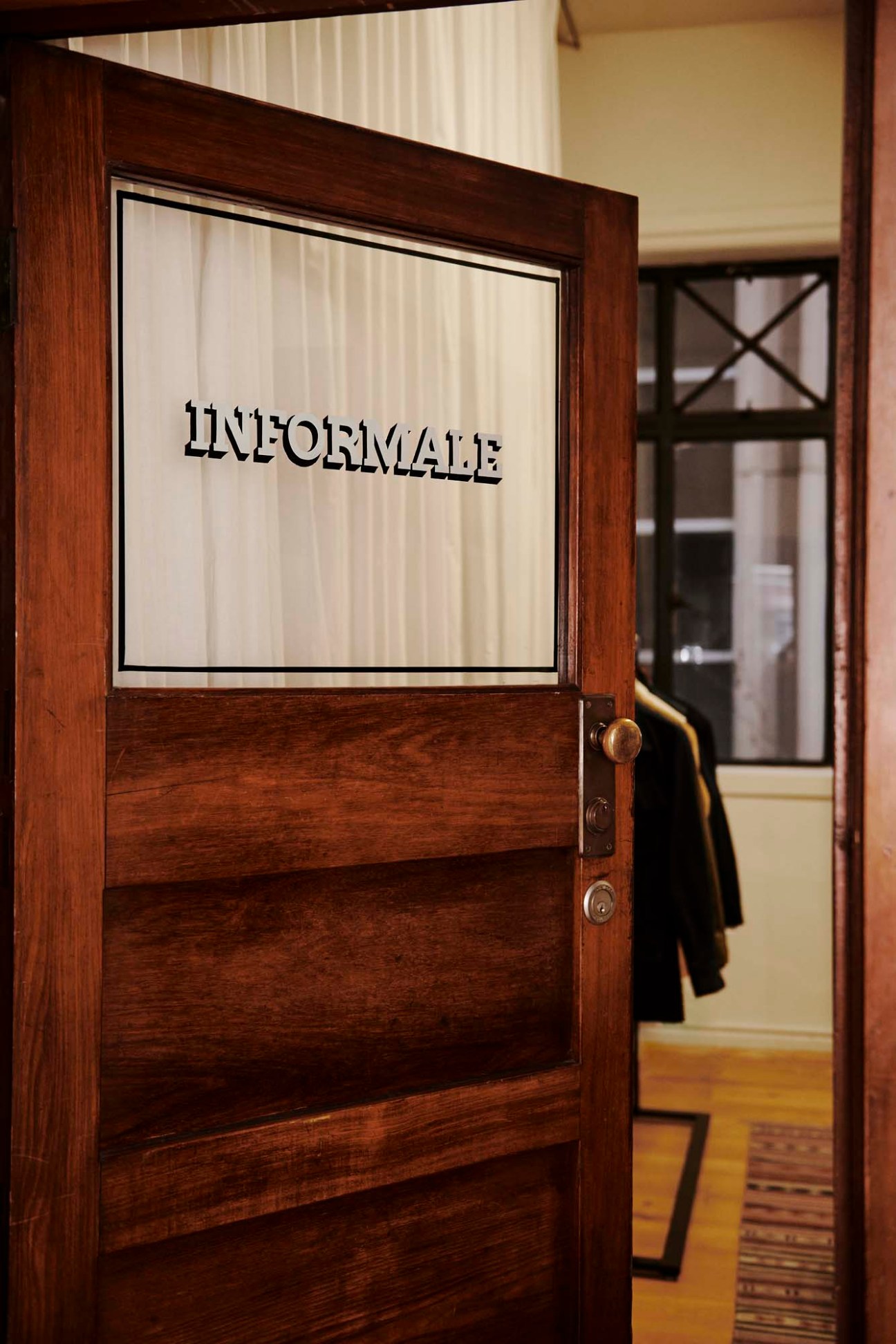 Informale's Melbourne atelier entrance with wooden door and brand signage visible inside.