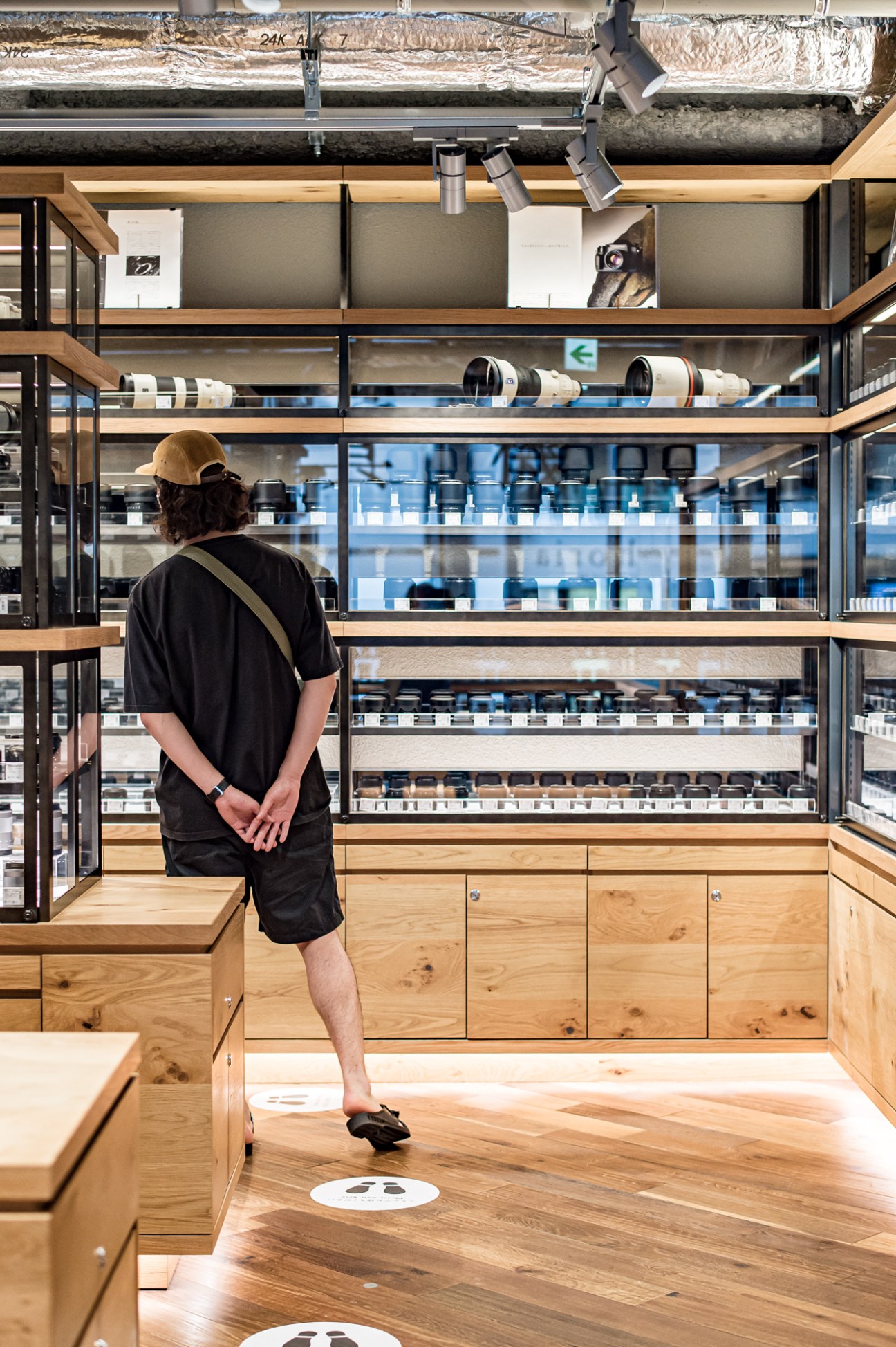 Customer browsing through vintage camera lenses in the used lens department of Kitamura Camera store
