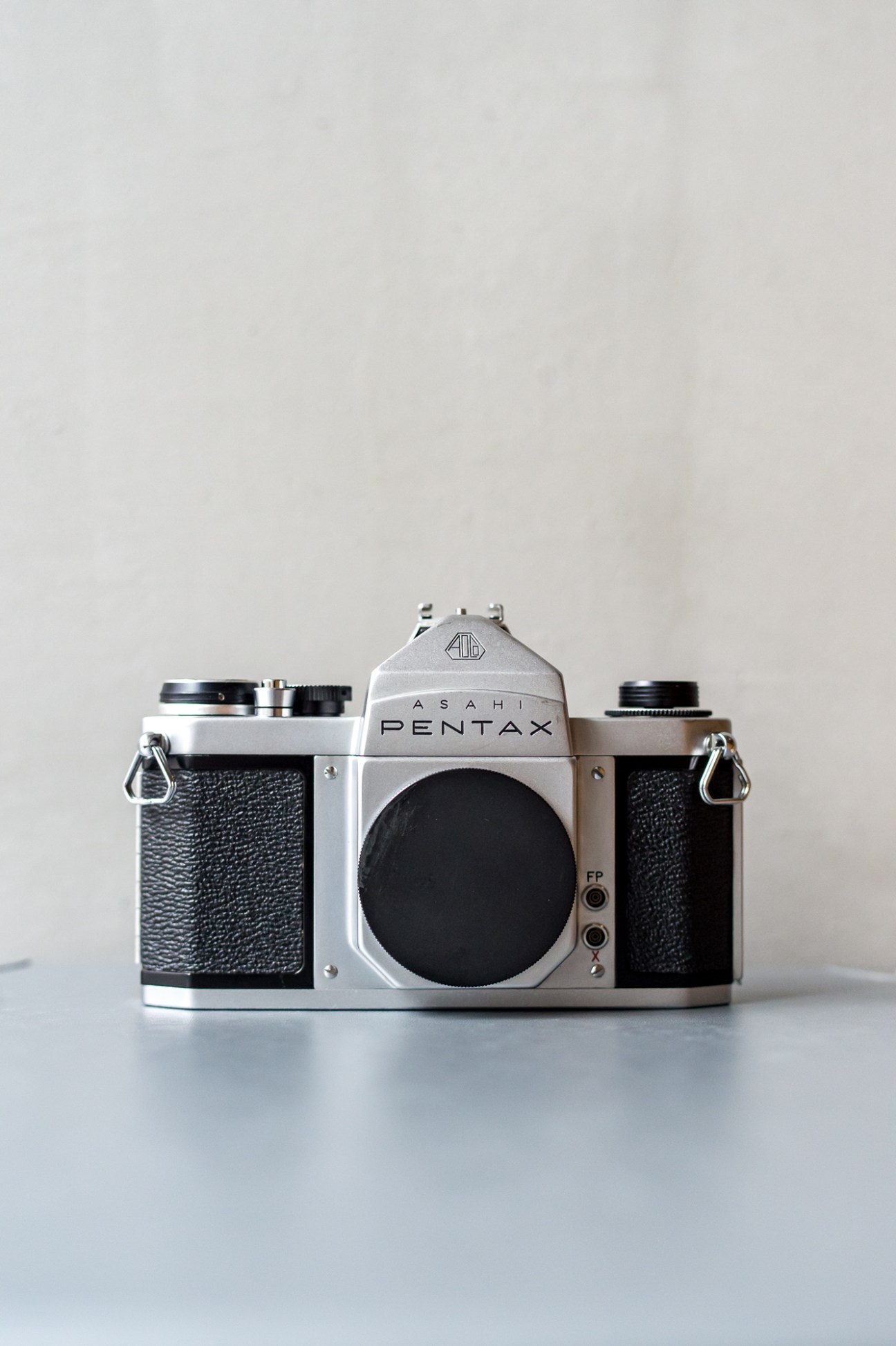 Classic Asahi Pentax S2 vintage camera with silver body and black leather grip displayed on white surface