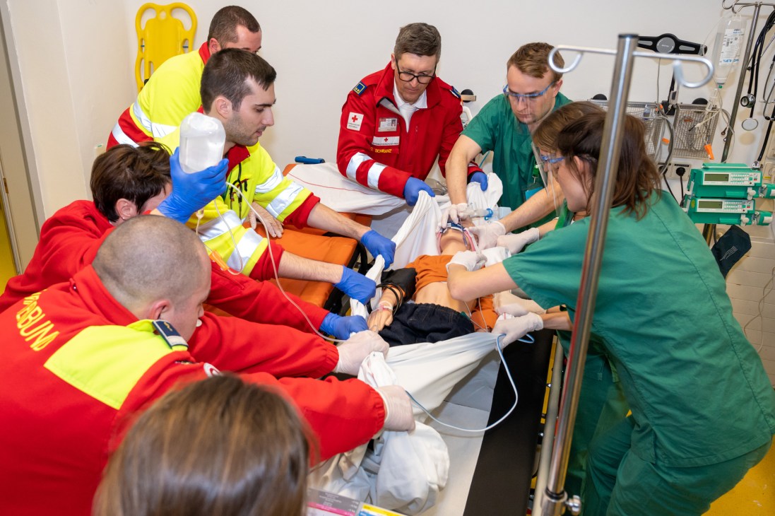 Emergency responders and medical staff treat a simulated patient during disaster preparedness training.